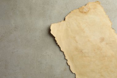 Gri masadaki eski parşömen kağıdı, üst manzara. Metin için boşluk