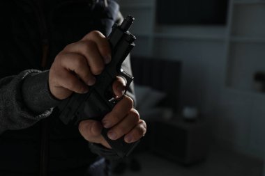 Yabancı evde silahlı tehlikeli bir suçlu, yakın plan. Silahlı soygun.