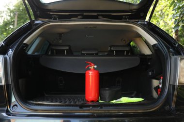 Bagajda kırmızı yangın söndürücü var. Araba güvenliği ekipmanı