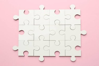 Pembe arkaplanda beyaz yapboz parçaları, üst görünüm