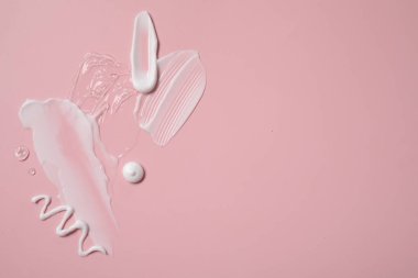 Pembe arka planda yüz kremi ve jöle, üst manzara. Metin için boşluk