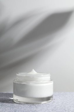 Gri desenli masada kavanozda yüz kremi. Kozmetik ürünü