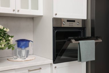 Mutfakta havluyla elektrikli fırını aç. Yemek pişirme aygıtı