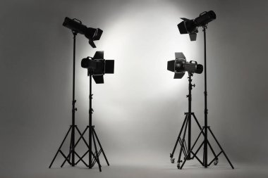 Stüdyoda gri fotoğraf ve profesyonel ışıklandırma ekipmanları