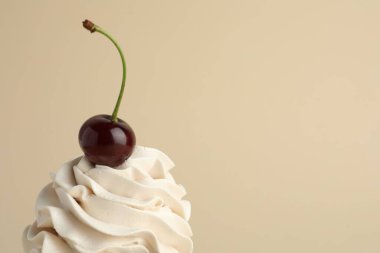 Kremalı ve kirazlı nefis kek bej arka planda, metin için yer var.