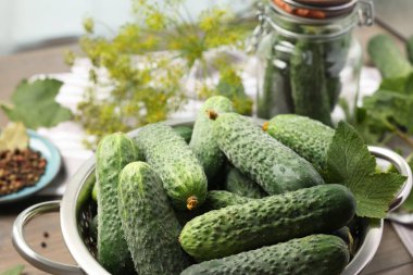 Masada taze yeşil salatalıklar var, yakın plan. Sebze turşusu