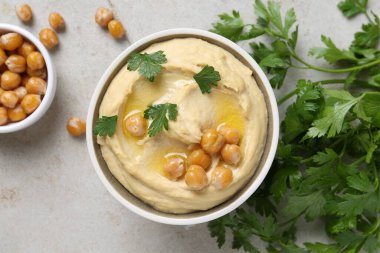 Zeytinyağı, nohut ve maydanozlu nefis humus açık gri masada, düz yerde.