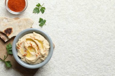Zeytinyağı ve kırmızı biberli nefis humus beyaz desenli masada servis edilir. Metin için boşluk