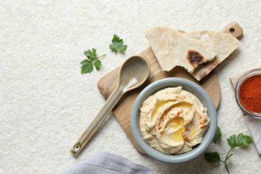 Zeytinyağı ve kırmızı biberli nefis humus beyaz desenli masada servis edilir.