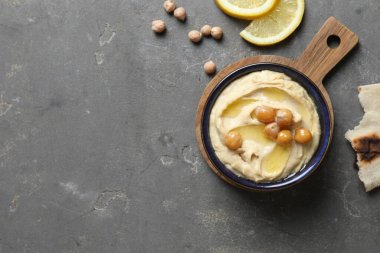 Zeytinyağlı lezzetli humus, nohut, limon ve pide gri desenli masa, düz yatak. Metin için boşluk
