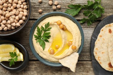 Zeytinyağlı lezzetli humus, nohut, limon ve pide ahşap masada, düz uzanmış