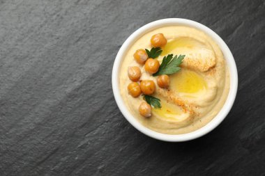 Zeytinyağlı enfes humus, bezelye ve maydanozlu kase gri desenli masa, üst manzara. Metin için boşluk