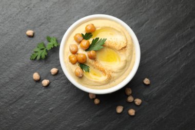 Zeytinyağlı lezzetli humus, bezelye ve maydanozlu gri desenli masa, düz uzanmış