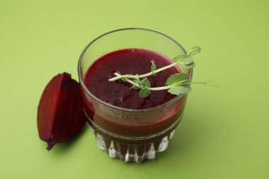 Yeşil masada yeşil camlı mikro yeşillikli leziz pancar suyu, yakın plan. Vejetaryen içeceği