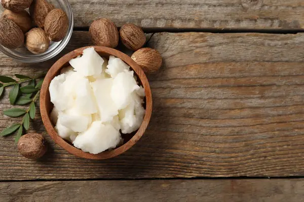 Doğal Shea tereyağı ve fındıklar ahşap masada, düz yerde. Metin için boşluk