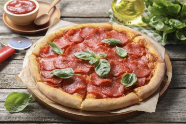 Lezzetli biberli pizza, malzemeler ve ahşap masa keskisi.