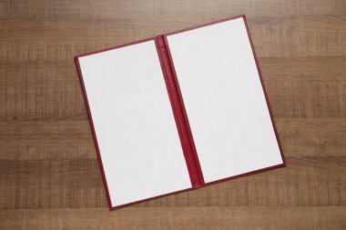 Ahşap masa üzerinde boş çarşafları olan sert kapaklı defter, üst manzara. Tasarım için model