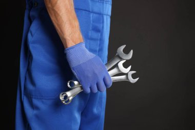 Siyah arka planda anahtarı olan oto tamircisi, yakın plan. Metin için boşluk