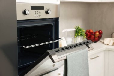 Mutfakta havluyla elektrikli fırını aç. Yemek pişirme aygıtı