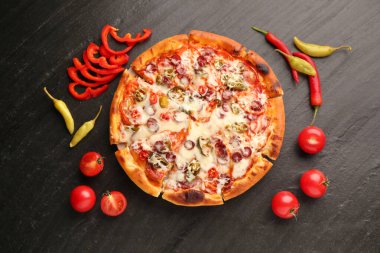 Lezzetli pizza Diablo koyu dokulu masada, düz yerde.