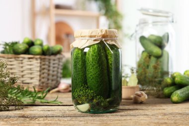 Kavanozda salatalık turşusu ve ahşap masada malzemeler, yakın plan.