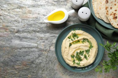 Zeytinyağlı enfes humus, gri desenli masa üzerinde pide ve maydanoz, düz yatak. Metin için boşluk