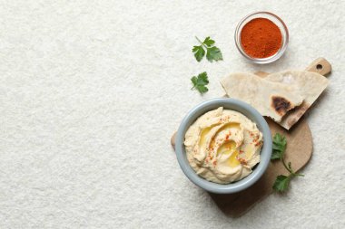 Zeytinyağı ve kırmızı biberli nefis humus beyaz desenli masada servis edilir. Metin için boşluk