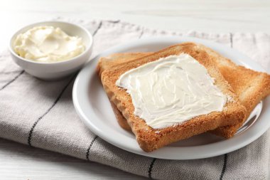 Lezzetli kızarmış ekmek dilimleri beyaz masada tereyağlı, yakın plan