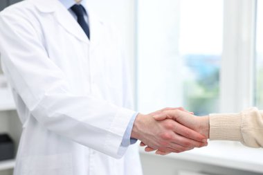 Doktor klinikte hastayla el sıkışıyor.