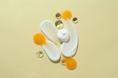 Bej arka planda farklı kozmetik ürünlerinin kokusu, üst görünüm