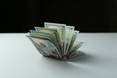 Siyah arkaplana karşı gri masadaki dolar banknotları