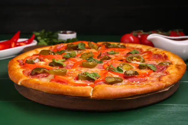 stock image Delicious pizza Diablo on green wooden table, closeup