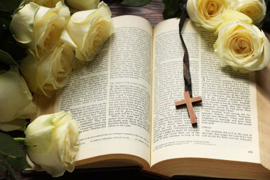 İncil, haç ve güller masada, yakın plan. Hıristiyanlık Dini