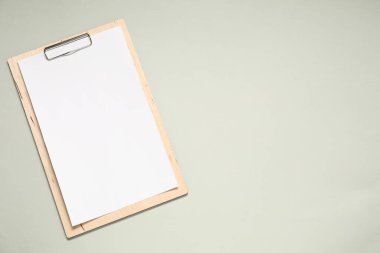 Açık gri arkaplan üzerine boş kağıt içeren pano, üst görünüm. Tasarım için model