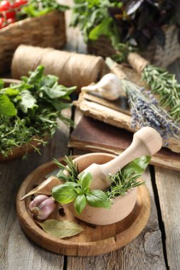 Değişik aromatik otlar, ahşap masa üzerinde kabuklu ve baharatlı havan.