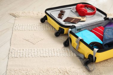 Seyahat eşyalarıyla dolu bavulu yerde aç, mesaj için yer aç