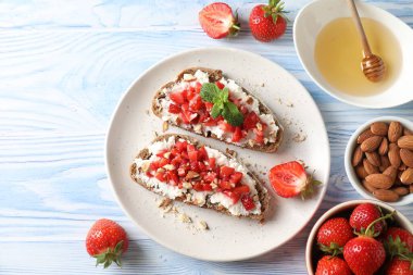 Ricotta peyniri, doğranmış çilek ve mavi ahşap masada nane şekeri.