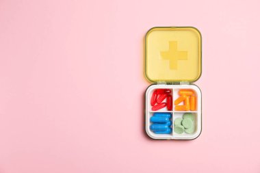 Pembe arka planda, organizatörde farklı haplar var. Metin için boşluk