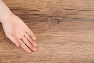 Ahşap masada avuç içi gösteren bir kadın, yazı için yeri olan üst manzara. Şiirsellik ve kehanet