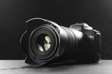 Gri masadaki modern fotoğraf makinesi, yakın plan. Fotoğraf ekipmanı.