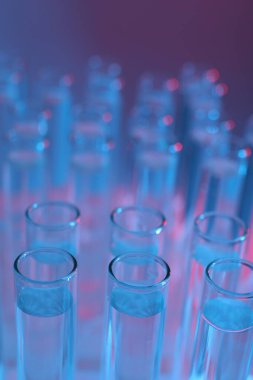 Renk arkaplanında birçok cam test tüpü, yakın plan