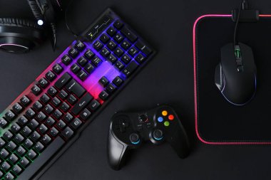 Bilgisayar faresi, RGB klavyesi, oyun denetleyici ve siyah arkaplan kulaklığı, düz yatış