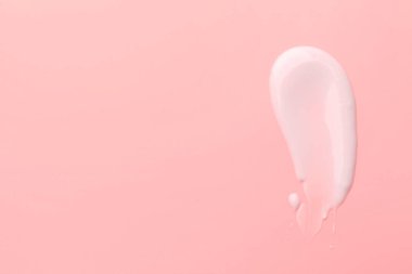 Pembe arka planda yüz kremi örneği, üst manzara. Metin için boşluk