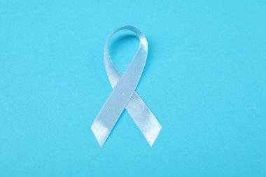 Renk arkaplanında açık mavi kurdele, üst görünümde. Prostat kanseri farkındalığı