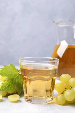 Gri masada olgun üzümler ve lezzetli meyve suyu.