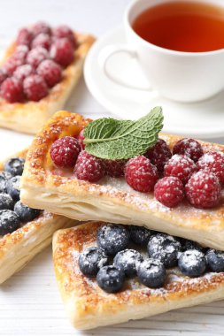 Böğürtlenli börek ve beyaz ahşap masada çay, yakın plan.