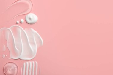 Pembe arka planda yüz kremi örnekleri, üst manzara. Metin için boşluk