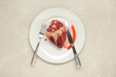 Çiğ kalp, çatal ve bıçak açık gri mermer masa, üst manzara