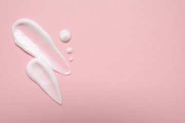 Pembe arka planda yüz kremi, üst manzara. Metin için boşluk