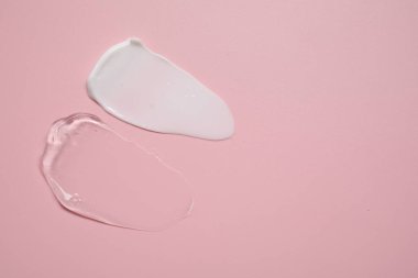Pembe arka planda yüz kremi ve jöle, üst manzara. Metin için boşluk